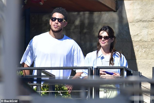 Keeping it cool: The daughter of Kris Jenner kept her appearance casual for the outing as she rocked an open blue and white striped shirt over tiny grey crop top