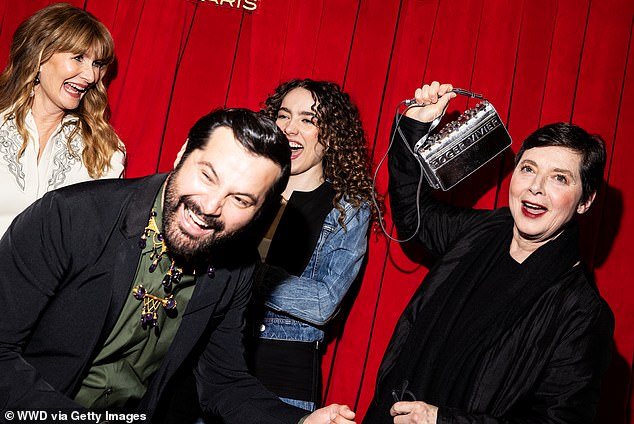 Her coat flattered her petite frame and featured sumptuous fur trim, and she brought out her features with a notably dark shade of red lipstick