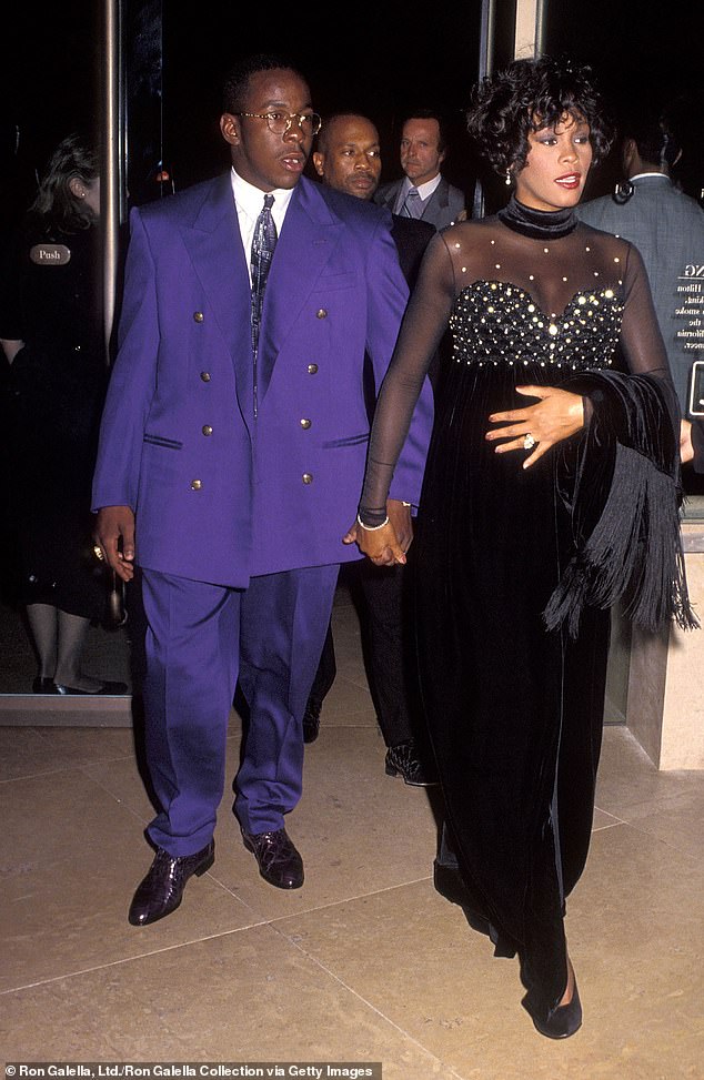 The ever-present Roberts (background) guarding Whitney Houston at a benefit event in 1992